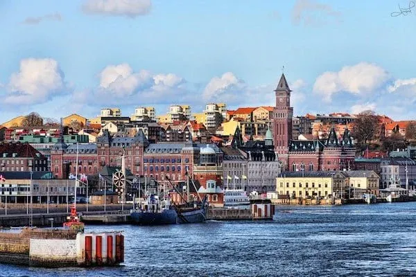 Vy av en stad vid vattnet med gamla byggnader och ett kyrktorn.